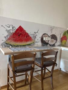 a table with a slice of watermelon on it at Apartma Ajda 2 , Jezerska cesta 65, Kranj in Kranj +4 photos