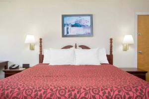 a hotel room with a bed with a red bedspread at A Red Dot Inn in Milledgeville