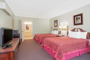a hotel room with two beds and a flat screen tv at A Red Dot Inn in Milledgeville