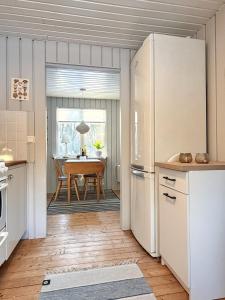 a kitchen with a white refrigerator and a table at Wonderful cottage close to lakes in Södra Rörum