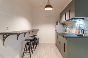 a kitchen with a counter and stools in it at Industrial Apartment ZERO in Bratislava