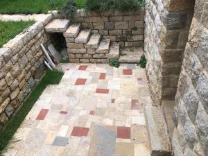 an outdoor patio with a stone wall at Dar el Maasser دار المعاصر in Maasser El Chouf