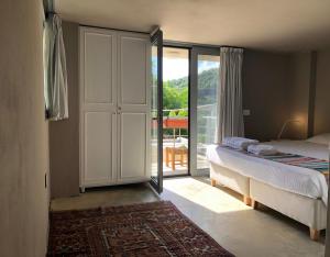 a bedroom with a bed and a door to a balcony at Dar el Maasser دار المعاصر in Maasser El Chouf