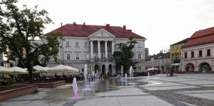 a fountain in the middle of a square with a building at Cicha Przystań w Centrum -Mała Sienkiewicza in Kielce
