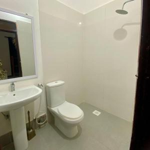 a white bathroom with a toilet and a sink at Fish House in Nungwi +47 photos