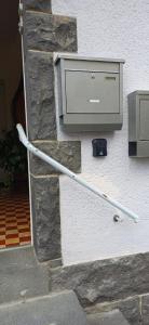 a hose hooked up to a stone wall with a mailbox at Ferienwohnung Kirschbaumblick in Ettringen