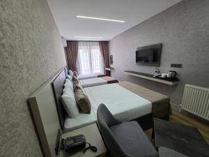 a hotel room with a bed and a chair at Real Hotel Van in Ipekyolu