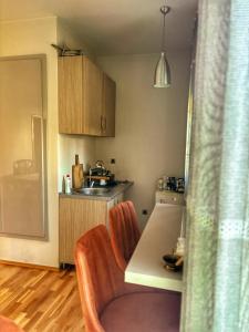 a kitchen with a table and a chair and a sink at L&K Old Town Apartment in Podgorica