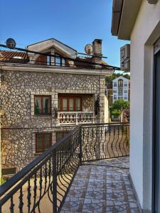 a stone building with a balcony next to a house at L&K Old Town Apartment in Podgorica