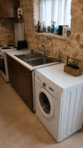 a kitchen with a washing machine and a sink at Lemoni's House in Krousón