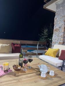 a table with two glasses of wine and wine bottles at Villa e Zanës in Boge
