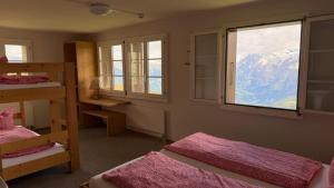 a room with two bunk beds and a window at Stöcki-Grindelwaldblick in Kleine Scheidegg