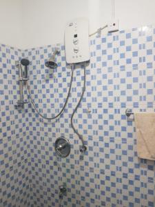 a shower in a bathroom with blue and white tiles at Calm Cottege in Gampaha