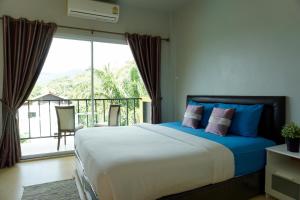 a bedroom with a large bed and a balcony at Lom La Lanta in Ko Lanta