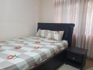 a bedroom with a bed with a floral comforter at Calm Cottege in Gampaha