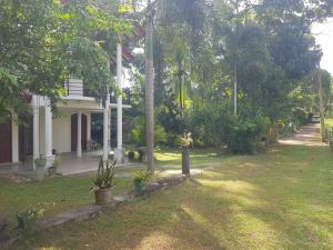 a house with a lawn in front of it at Calm Cottege in Gampaha