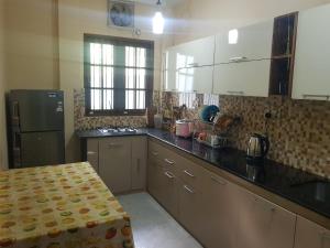 a kitchen with a black counter top and a refrigerator at Calm Cottege in Gampaha +7 photos
