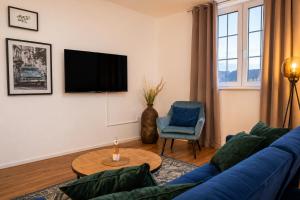 a living room with a blue couch and a tv at Schängel Chic 19 in Koblenz