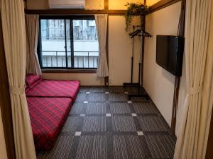 a living room with a red couch and a tv at Artist's Studio in Mitaka