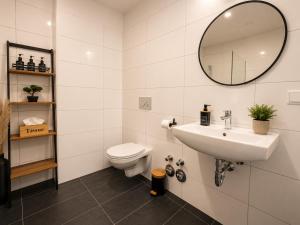 a bathroom with a sink and a toilet and a mirror at Schängel Chic 19 in Koblenz
