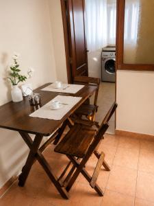a wooden dining room table with chairs and a kitchen at Hipódromo Sky Penthouse in Cochabamba +7 photos