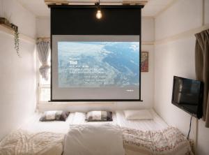 a projection screen above a bed in a room at Artist's Studio in Mitaka