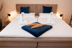a bed with white sheets and blue pillows at Schängel Chic 19 in Koblenz