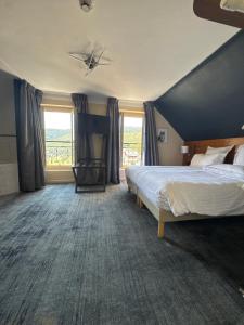 a hotel room with a bed and a large window at Hôtel Génépi in Beuil