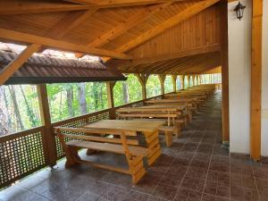 a row of wooden benches on a covered porch at Villa Hukic in Tuzla