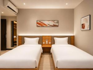 two beds sitting next to each other in a room at Hotel 7 Days Duc Hoa in Ấp Bình Tả (2) +77 photos