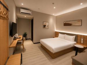 a hotel room with a bed and a desk at Hotel 7 Days Duc Hoa in Ấp Bình Tả (2)