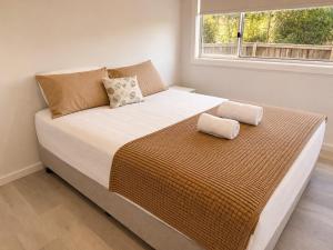 a large bed in a bedroom with a window at 18 Pimpama Home in Pimpama