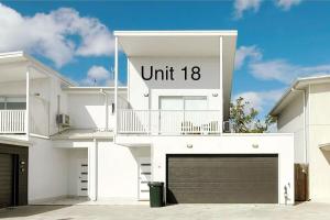 a white house with a unit sign on it at 18 Pimpama Home in Pimpama