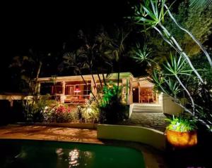 a house at night with a swimming pool at MangOdiamant, la vue sur mer, la plage à pied in Le Diamant