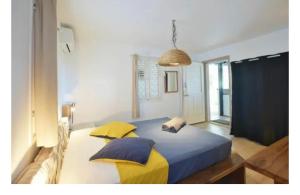 a bedroom with a large bed with yellow and blue pillows at MangOdiamant, la vue sur mer, la plage à pied in Le Diamant