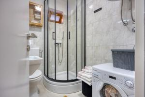 a bathroom with a shower and a washing machine at Holiday House Ante in Žminj +20 photos