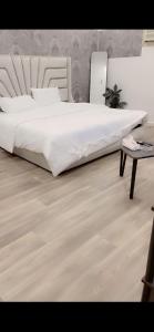a bedroom with a large white bed and a table at Ksa2 in Hail