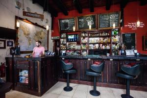 a man standing at a bar in a restaurant at Island Life Hostel in Santo Domingo
