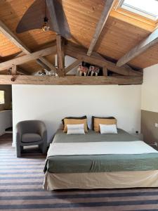 a bedroom with a large bed and a chair at Le loft chambre et salon climatisés in Croix-Chapeau +13 photos