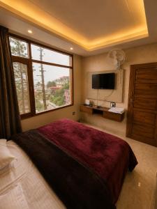 ein Schlafzimmer mit einem großen Bett und einem großen Fenster in der Unterkunft PiNE&PEAK in Shimla