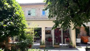a house with glass doors in a yard with trees at Louminai in Donzère