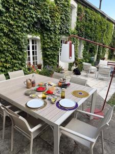 a wooden table with chairs and a tableweredotentotent at Le loft chambre et salon climatisés in Croix-Chapeau
