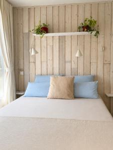 Ein Schlafzimmer mit einem Bett und zwei Topfpflanzen an der Wand in der Unterkunft Homemade Studio in Liebshausen