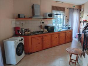 a kitchen with a stove and a washing machine at Lacaz Vacances in Tamarin
