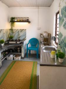 a kitchen with a sink and a blue chair at FS Hotel & villa in Arugam Bay