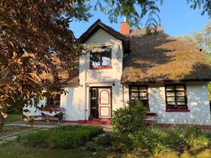 an old white house with a thatched roof at Buhne 27 in Dierhagen