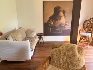 a living room with couches and a painting on the wall at Buhne 27 in Dierhagen