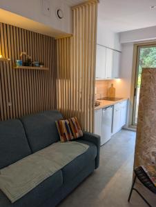 a living room with a blue couch and a kitchen at Studio in a luxury community in Nice