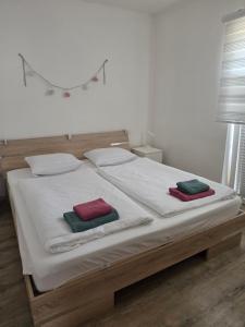 a bed with two pillows on it in a room at Apartment AlpiPond in Kamnik