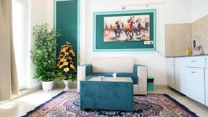 a living room with a blue couch and a rug at Sofitel Caravanserai 1BHK Noida, Spectrum Mall Sector 75 in Noida